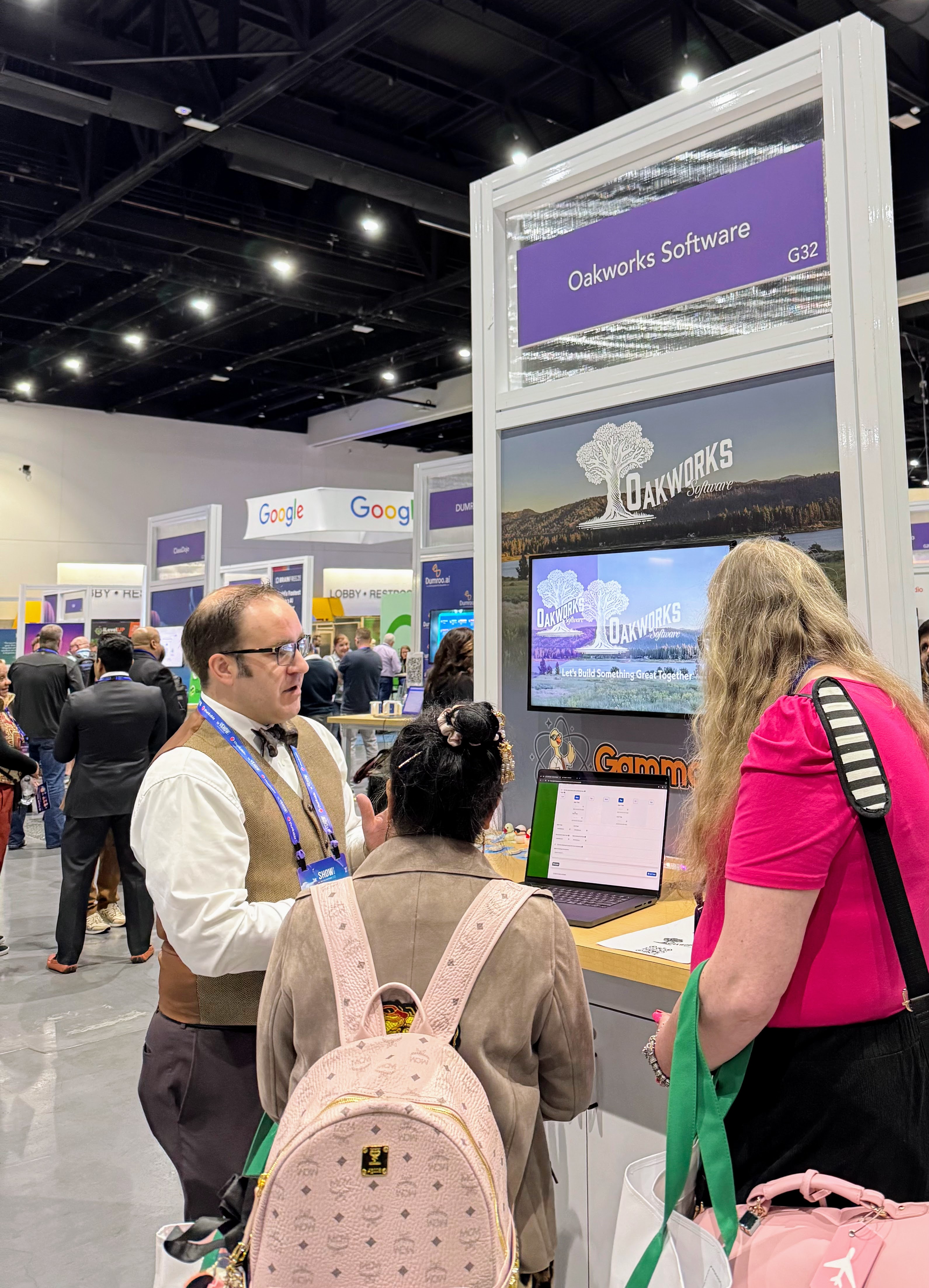 Brett Haddoak talking with two attendees at the Oakworks Software booth.