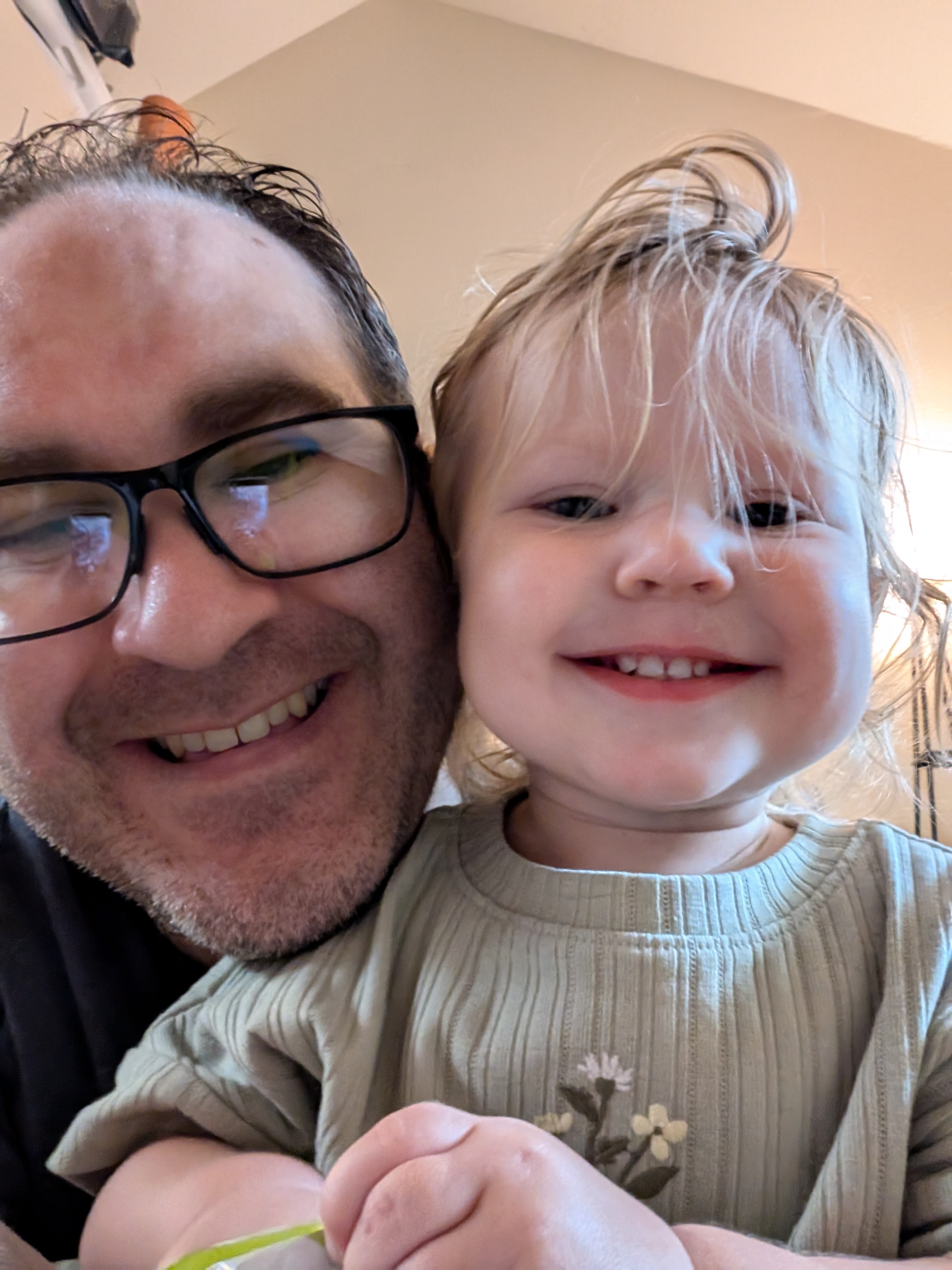 Close-up selfie of Brett Haddoak and his smiling young daughter, cheek to cheek.